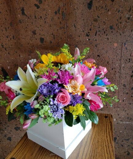 Caja de madera artesanal con flores mixtas primaverales para envío a domicilio en Ciudad Juárez y El Paso.