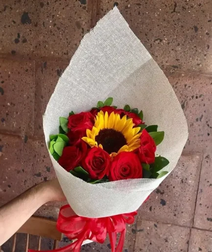 Ramo de 1 girasol central y 6 rosas rojas frescas para envío sin costo en Ciudad Juárez.