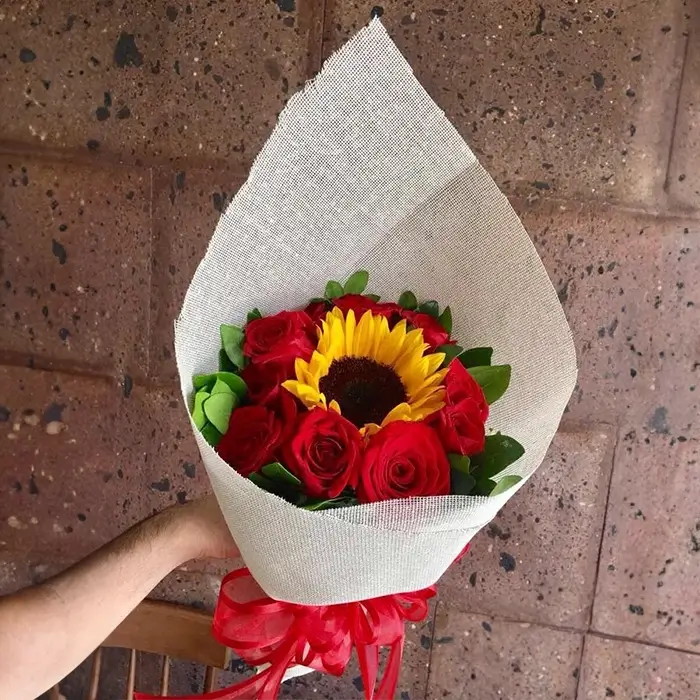 Ramo de 1 girasol central y 6 rosas rojas frescas para envío sin costo en Ciudad Juárez.