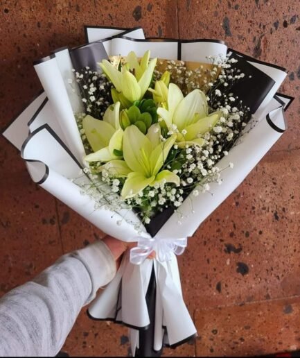 Ramo de lilis blancas y rosas de tallo largo con follaje verde para envío sin costo en Ciudad Juárez.