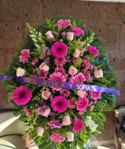 Corona fúnebre de rosas, gerberas y perritos en Ciudad Juárez.